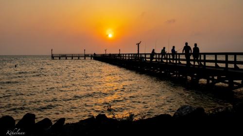Fishing pier at sunset by Kathy Thalman